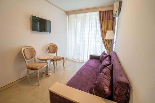 a living room with a purple couch and chairs at Hotel Sulina International in Mamaia