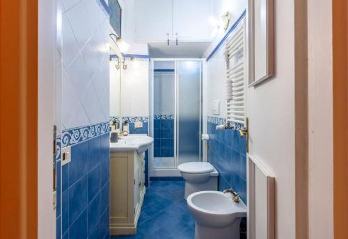 a blue bathroom with a toilet and a sink at Casa Rio in Rome