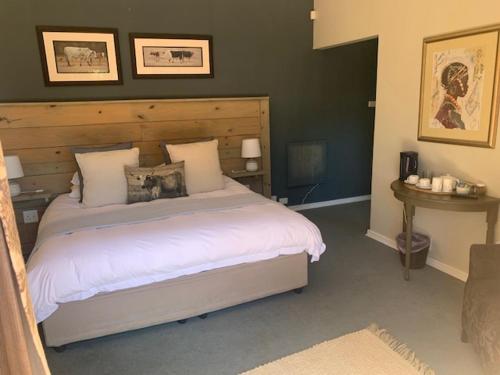 a bedroom with a large bed with a wooden headboard at Notting Hill Lodge in Balgowan