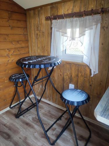 two tables in a room with a window at Ubytování v klimatizovaných chatičkách Štít in Chlumec nad Cidlinou