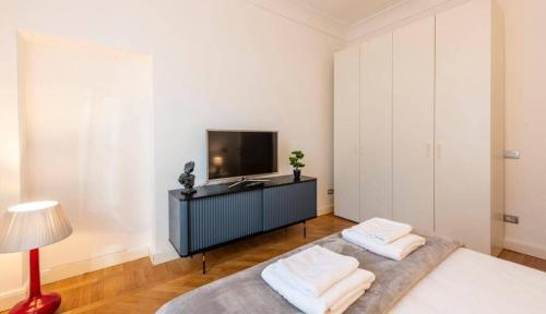 a bedroom with a bed and a tv and a lamp at Milan Royal Suites - Centro in Milan