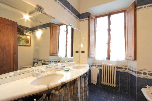 La salle de bains est pourvue de 2 lavabos et d'un grand miroir. dans l'établissement Villa Il Colle B&B, à Bagno a Ripoli