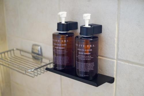 阿克羅蒂里的住宿－Anya Suites Santorini，浴室内架上的两瓶除臭剂