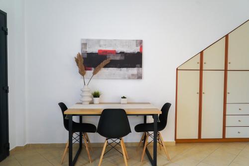 a dining room table with chairs and a painting on the wall at Anya Suites Santorini in Akrotiri