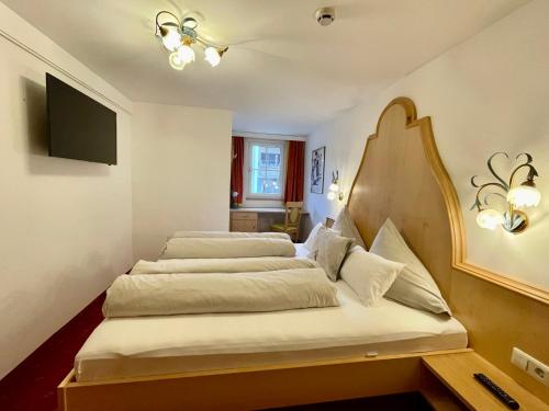 a bedroom with two beds and a flat screen tv at Arlen Lodge Appartement in Sankt Anton am Arlberg