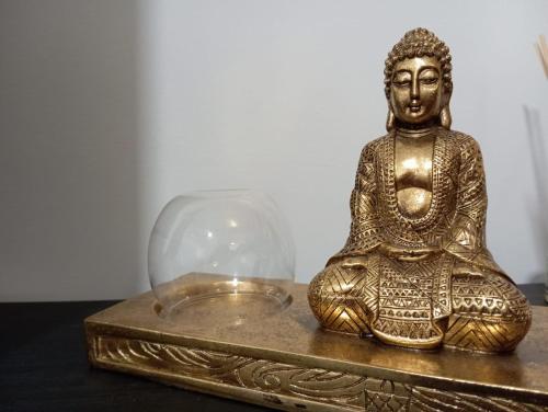 une statue d'or d'un buddha dans un dôme de verre dans l'établissement Gardenia Apartment, à Séville