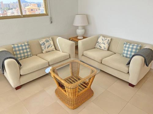 a living room with two couches and a table at Oasis Frente al Mar. Parking Gratis in El Campello