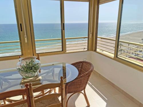 una sala da pranzo con tavolo, sedie e vista sull'oceano di Oasis Frente al Mar. Parking Gratis a El Campello