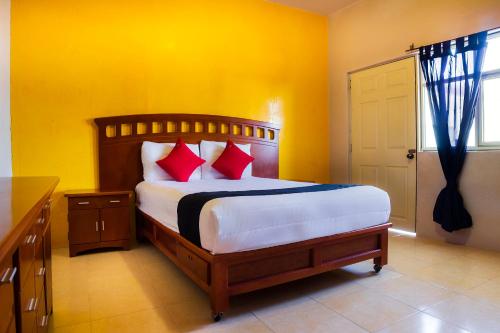 um quarto com uma cama grande e almofadas vermelhas em Capital O Del Valle, Tecamachalco em Tecamachalco