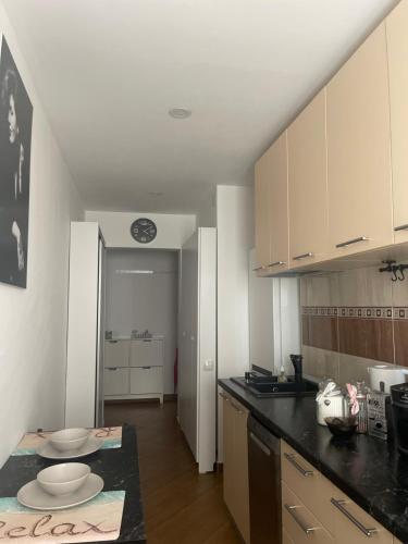 a kitchen with white cabinets and a black counter top at Garsoniera Relax Drumul Taberei in Bucharest