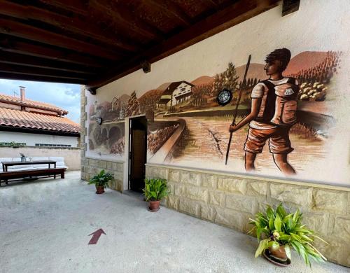 een muurschildering van een man aan de zijkant van een gebouw bij ALBERGUE SAN NICOLAS in Larrasoaña