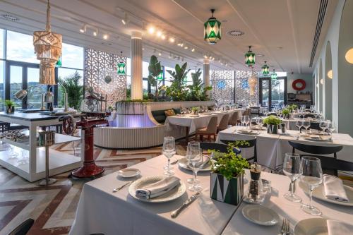 un restaurante con mesas y sillas blancas y ventanas en Villa in Spain at Las Colinas Golf & Country Club, en Orihuela Costa