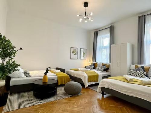 a room with three beds and a table at Chic Vienna Apartment in Vienna