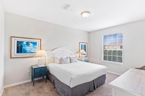 Habitación blanca con cama y ventana en Top Villas - Vista Cay 213, en Orlando