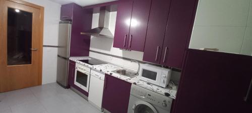 cocina con armarios morados y lavadora en Apartamento con 2 dormitorios, garaje y terraza junto a Valladolid en Valladolid