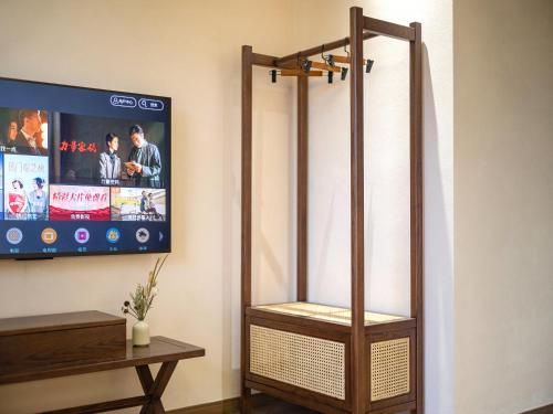 a bathroom with a tv and a wooden stand up shower at Lingxi Riverview Boutique Homestay - Phoenix Ancient Town in Fenghuang