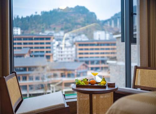a hotel room with a table with fruit on it at Lingxi Riverview Boutique Homestay - Phoenix Ancient Town in Fenghuang