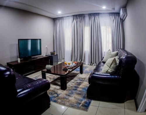 a living room with a leather couch and a coffee table at MUKUBA HOTEL in Ndola