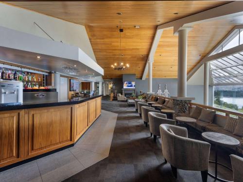 a bar in a restaurant with tables and chairs at Mercure Queenstown Resort in Queenstown