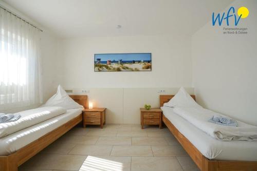 Cette chambre comprend 2 lits et une photo murale. dans l'établissement Villa Schoen 58091, à Borkum