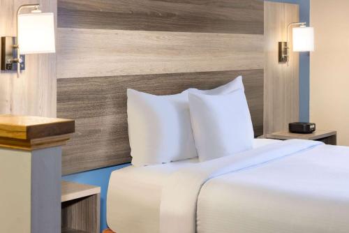 a bed with white pillows in a hotel room at Baymont by Wyndham Budd Lake in Budd Lake