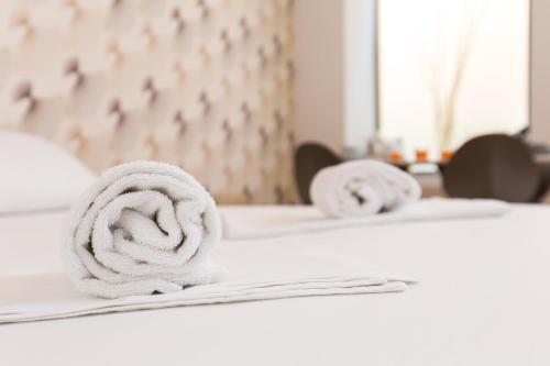 a pile of towels sitting on top of a bed at Vienna Stay Apartments Belvedere in Vienna