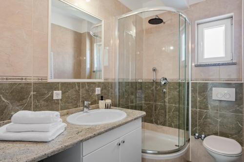 a bathroom with a sink and a shower and a toilet at Villa Ana with private 50m2 pool, 7 bedrooms, 7 bathrooms, 18 persons max in Stanići