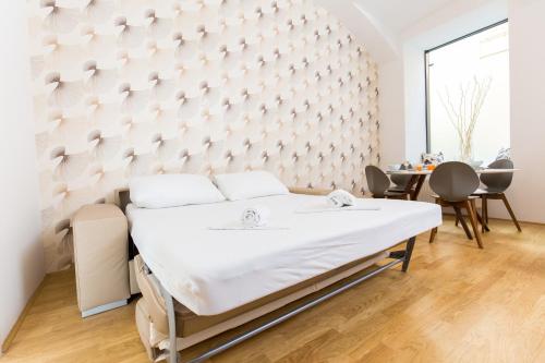 Ce lit se trouve dans une chambre dotée d'un mur. dans l'établissement Vienna Stay Apartments Belvedere, à Vienne