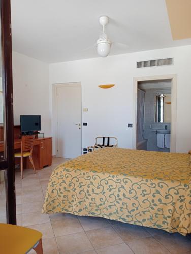 a bedroom with a bed and a desk and a television at Hotel Bel Sit in Senigallia
