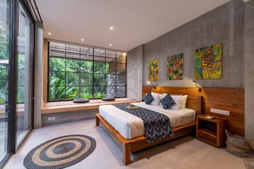 a bedroom with a large bed and a window at The Nani in Ubud