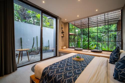 a bedroom with a bed and a large window at The Nani in Ubud