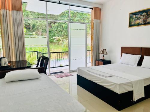 a bedroom with two beds and a balcony at Eco Resort Kandy in Kandy