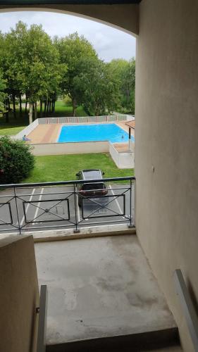 un balcon avec vue sur une piscine dans l'établissement Vaux Pontaillac Le soleil et la mer, à Vaux-sur-Mer