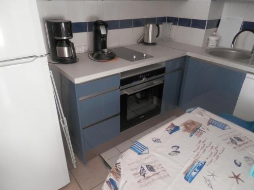 - une cuisine avec une table et une serviette au sol dans l'établissement Vaux Pontaillac Le soleil et la mer, à Vaux-sur-Mer