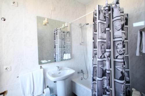a bathroom with a sink and a shower curtain at PR Plaza de Galicia in Santiago de Compostela