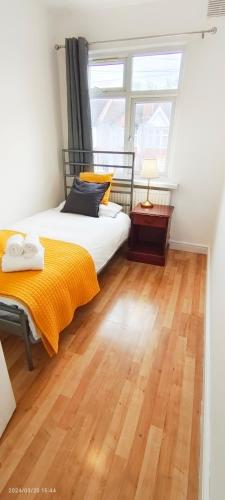 a bedroom with a bed and a wooden floor at Maple House near Wembley Stadium in London