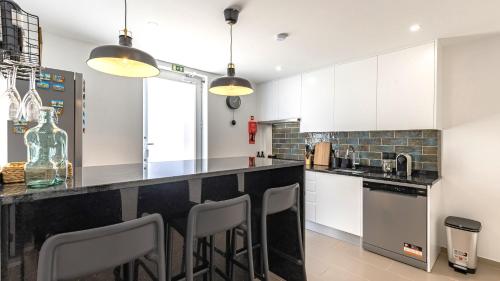 a kitchen with white cabinets and a black counter top at Amazing 3BDR Duplex in Lisbon by LovelyStay in Lisbon