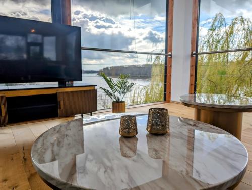 a living room with a table and a large tv at Villa Rheinblick in Cologne