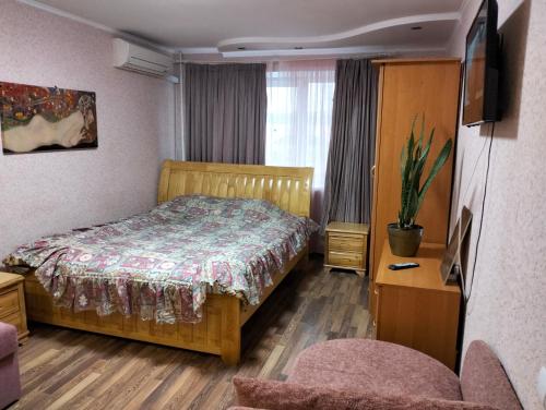 a bedroom with a bed and a chair and a tv at Apartment on 8 Marta Street in Mykolaiv