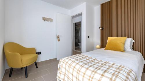 1 dormitorio con 1 cama y 1 silla amarilla en Amazing 3BDR Duplex in Lisbon by LovelyStay, en Lisboa