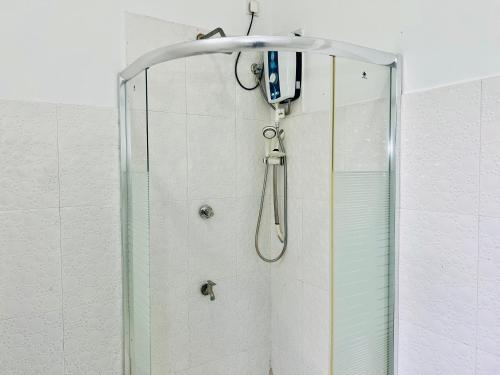 um chuveiro com um telefone pendurado na parede em Eco Resort Kandy em Kandy