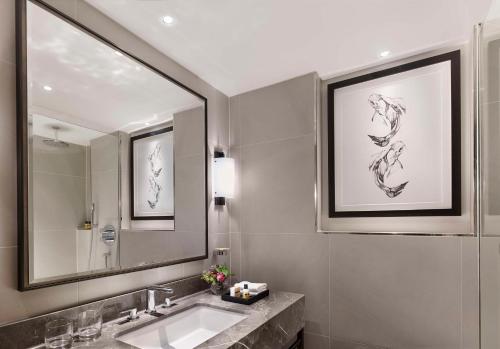 y baño con lavabo y espejo. en Hyatt Regency London - The Churchill, en Londres
