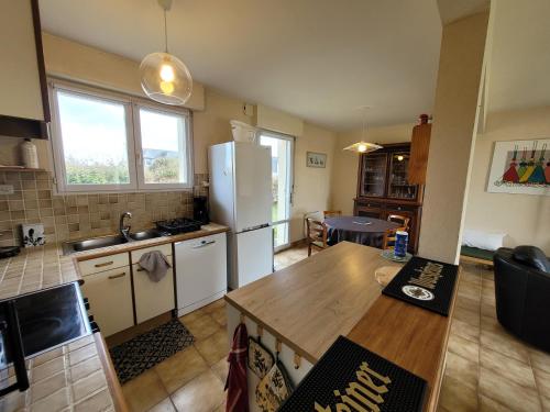 Il comprend une cuisine équipée d'un réfrigérateur et d'une table. dans l'établissement Les Voiliers, évasion à la mer, à Plouescat