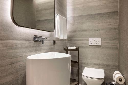 a bathroom with a white sink and a toilet at Ankara HiltonSA in Ankara