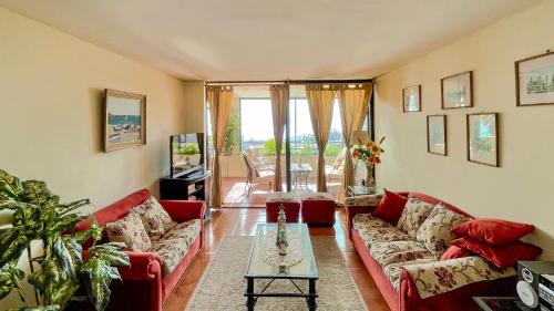 una sala de estar con sofás rojos y una mesa. en Departamentos Heimat 4, en La Serena