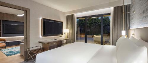 a bedroom with a large bed and a television at Ankara HiltonSA in Ankara