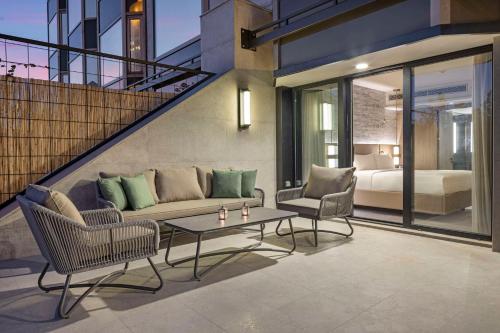 a living room with a couch and chairs and a bed at Ankara HiltonSA in Ankara