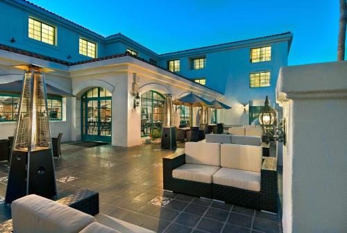 a living room with white couches in front of a building at DoubleTree by Hilton San Pedro in San Pedro