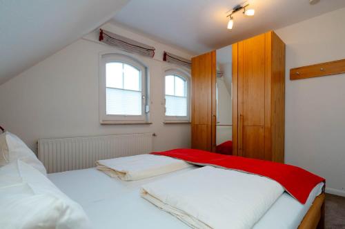 a bedroom with two beds and two windows at Ferienwohnung Nordwind in Westerland