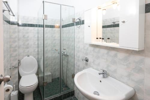 uma casa de banho com um WC, um lavatório e um chuveiro em Hotel Venetia em Perdika